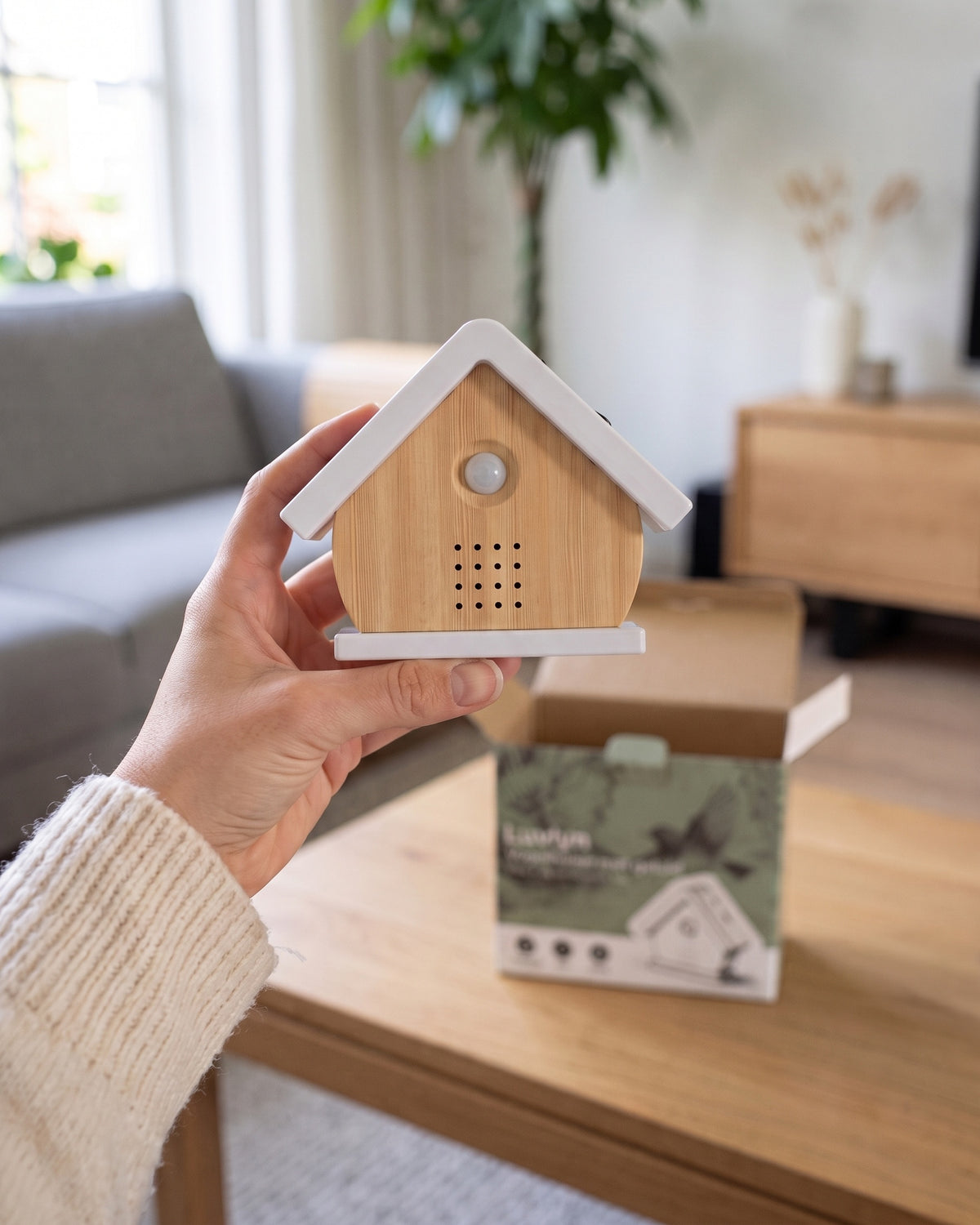 Het vogelhuisje in Berk net uitgepakt, in de hand, met de open doos op tafel